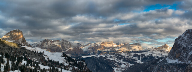 Sunset over mountains of Alta Badia in a winter end of the day with cloudy sky , Dolomites