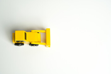 Yellow toy bulldozer, top view copy space. Metaphor to remove something, demolish. Construction...