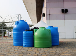 Green and blue barrels for agriculture. Plastic containers for storing water and fertilizers.