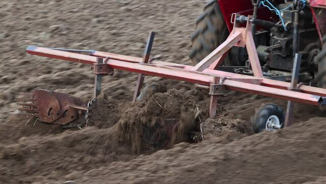 Homemade attachment harrow cultivator for mini tractor cultivated land in potato field.