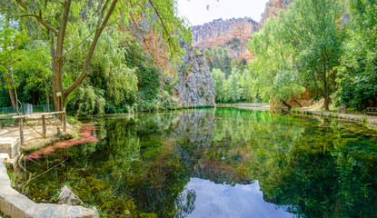 Fototapeta na wymiar Stone monastery garden park with lush waterfalls