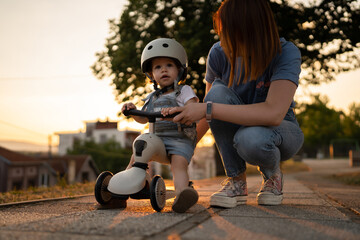 Mother and daughter toddler play with children's kid's kick scooter © Miljan Živković