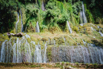 Stone monastery garden park with lush waterfalls