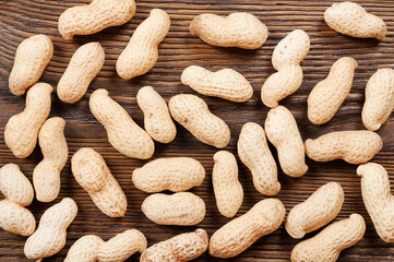 Peanuts in shell scattered on a wooden table. Background with nuts.
