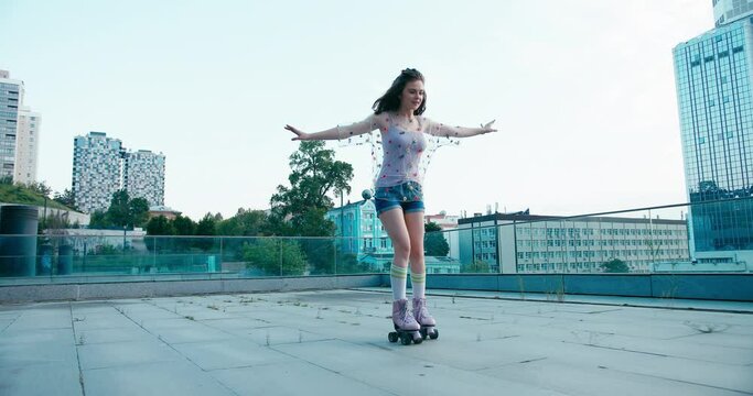 Young fit woman on roller skates riding outdoors on urban street. Smiling girl with rollerblading on sunny day