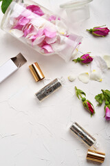  perfume empty bottles around roses and petals settled at authentic provence background. Perfumer, beauty and trendy concept.  flat lay