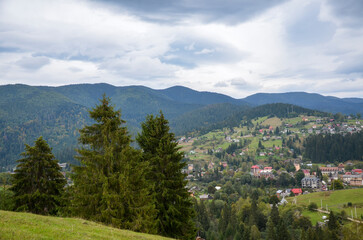 Beautiful scenic overcast countryside landscape with forested hills and mountain village Vorokhta...