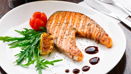 Grilled salmon steak with cherry tomato and arugula
