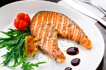 Grilled salmon steak with cherry tomato and arugula