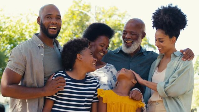 Portrait Of Loving Multi-generation Family Standing Outside In Garden, Park Or Countryside Looking At Camera- Shot In Slow Motion