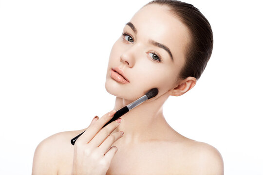 Beautiful girl holding makeup brush foundation on white background