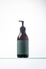 A mock-up of a brown dispenser with cosmetics with a place for your logo on a glass shelf. Natural cosmetics.