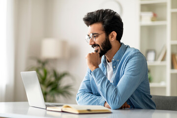 Portrait Of Smiling Handsome Indian Man Working With Laptop At Home Office