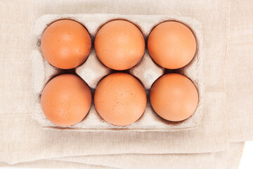 Natural organic chicken eggs in cardboard package, top view.