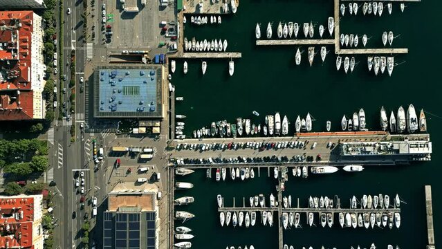Aerial top down view of seafront streets in Trieste and sailboats and yachts in marina, Italy