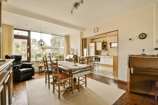 a living room with wood flooring and large windows looking out onto the garden area in the photo is taken from inside
