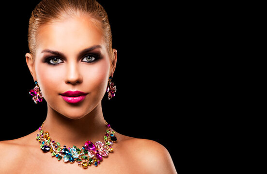beautiful woman with dark makeup and pink lipstick posing on black background wearing flower spring and summer jewellry necklace