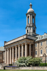 Obraz premium The Old Main building on the campus of Penn State University in summer sunny day, State College, Pennsylvania.