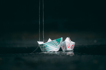 paper boats are standing on the street in a puddle