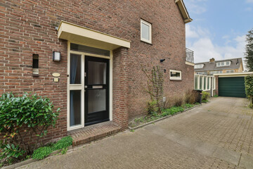 an outside view of a brick building with two garages on the left and one door open to the right
