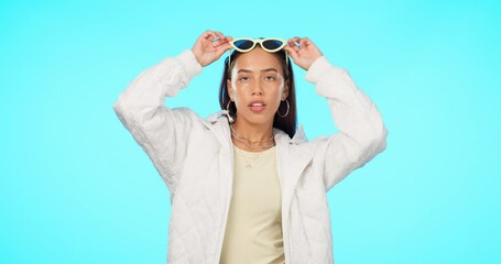 Fashion, sunglasses and portrait of a cool woman with style or modern clothing isolated in studio blue background. Aesthetic, gen z and young female person confident and elegant in designer brand