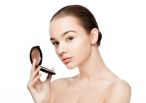 Beauty makeup model holding powder foundation container with reflection on white background