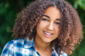 Outdoor portrait of beautiful happy mixed race African American girl teenager female child smiling with perfect teeth