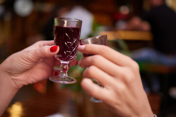 people at the bar try tinctures, red tinctures in glasses, alcoholic shots.