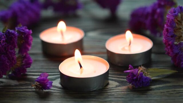 Candle. Tea Lights Candle. Mini Tealight candles for home decoration. Flowers on wooden table. Dripless and long lasting paraffin or white beeswax. Good for essential oil diffuser or aroma lamps.