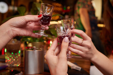 people at the bar try tinctures, red tinctures in glasses, alcoholic shots.