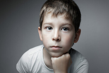 Portrait of a handsome boy looking in cam. Isolated on the gray background