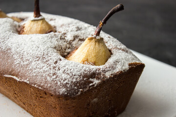 Chocolate cake with poached pear on dark background