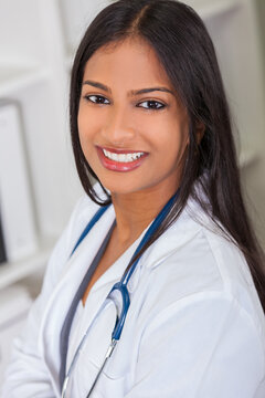 An Indian Asian female medical doctor in a hospital office happy and smiling with stethoscope