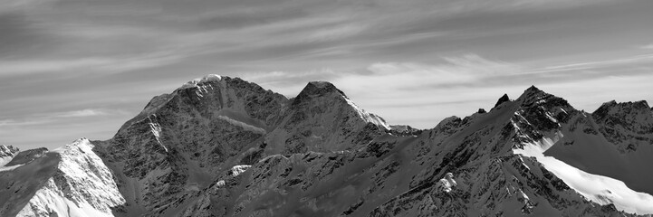 Fototapeta na wymiar Black and white panorama on winter snow mountains. Caucasus Mountains, Elbrus Region. View from slope of Mount Elbrus.