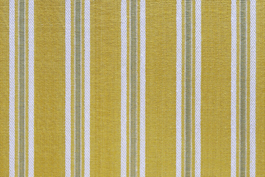 Natural linen texture as background. Cotton fabric with yellow and white line striped pattern, texture close up. Backdrop, wallpaper. Matereal for clothes, curtain and upholstery