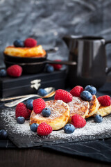 Cottage cheese pancakes decorated with fresh raspberries and blueberries