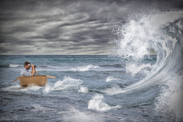 Businessman in a cardboard sails in a storm at sea. Deal with the crisis like a stormy sea concept