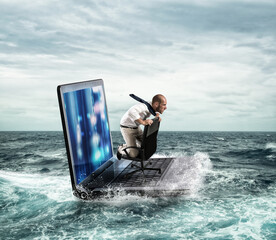 Businessman sailing on a laptop in the sea