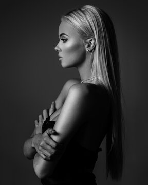 hairstyle, haircare and fashion concept - natural blond woman profile portrait with beautiful hair on grey background in monochrome