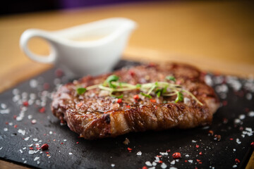 Prime Black Angus New York strip steak served on a warm stone board