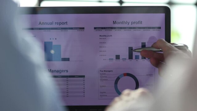 Business partnership coworkers using a tablet to chart company financial statements report and profits work progress and planning in office room.