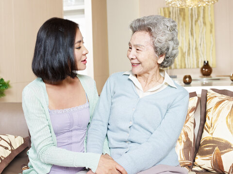 senior asian mother chatting with adult daughter at home