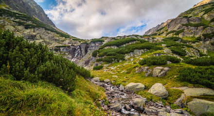 Fototapeta na wymiar Mountain Landscape with Skok Waterfall on Cloudy Day. Mlynicka Valley, High Tatra, Slovakia.