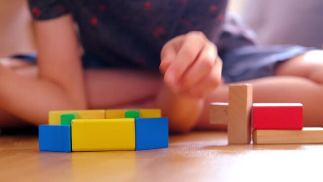 smart child, schoolboy playing with educational toy, wooden geometric figures, blocks in boy's hands, developing brain games, concept childhood, earlier child development, creativity, early training