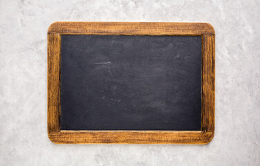 Small empty chalkboard on a light grey textured background. Blank. Blackboard Background. Blackboard texture