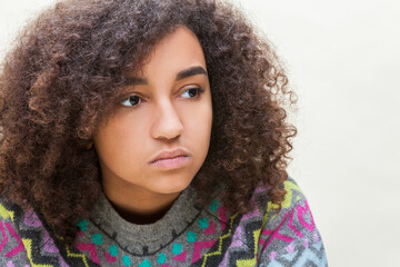 Beautiful mixed race African American girl teenager female young woman sad depressed or thoughtful