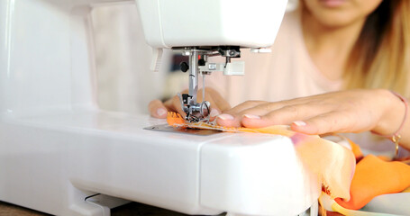 Close up shot of sewing machine in process while female using it.