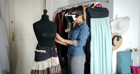 Young female in casual clothing wearing VR glasses and working with mannequin in parlour.