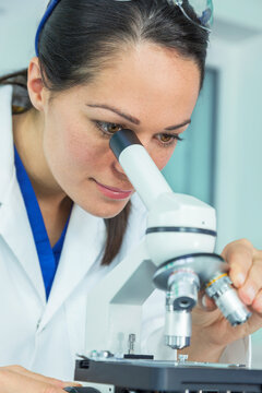 A female medical or research scientist using her microscope in a lab or laboratory.