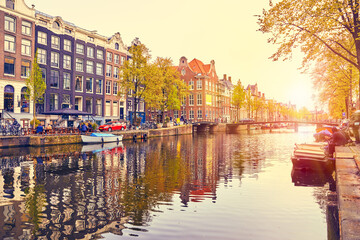 Fototapeta premium Channel in Amsterdam Netherlands houses river Amstel landmark old european city spring landscape.